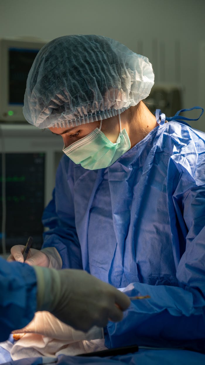 Surgeon in blue scrubs and mask performing surgery in a hospital operating room.