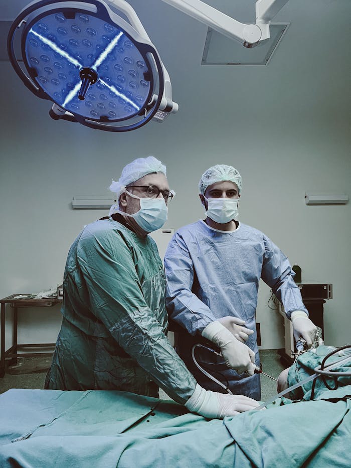 Surgeons working intently in a well-equipped operating room during surgery.