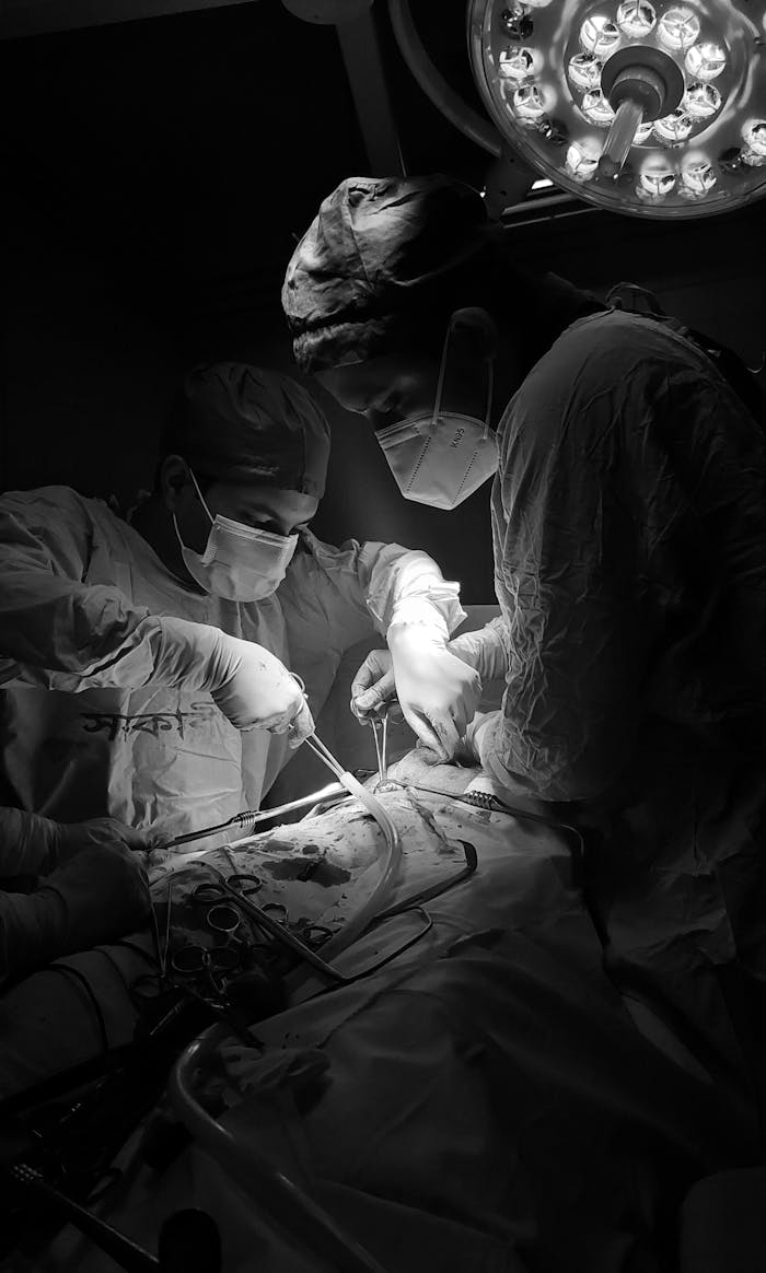 Focused surgeons conduct a critical operation in a dimly lit hospital operating room.