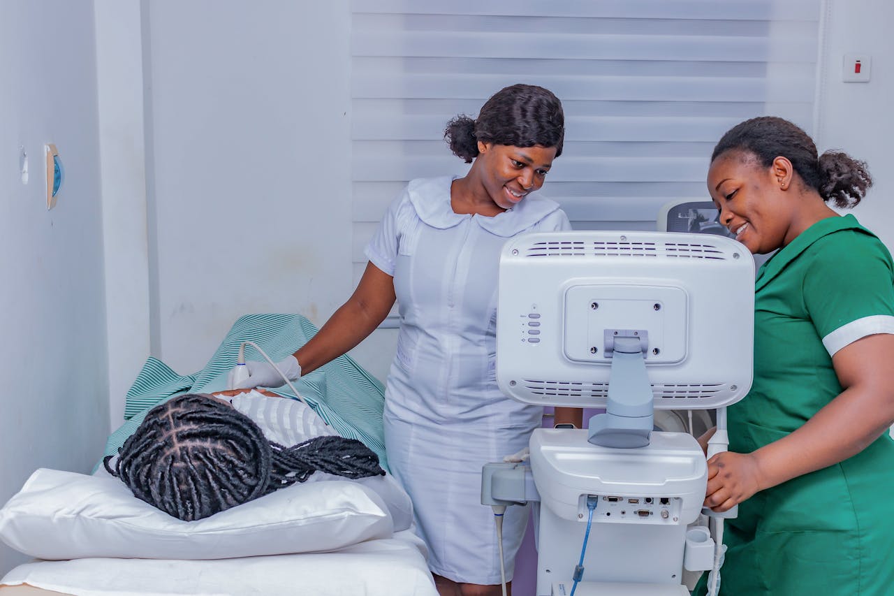 Smiling healthcare professionals performing an ultrasound examination in a clinical setting.