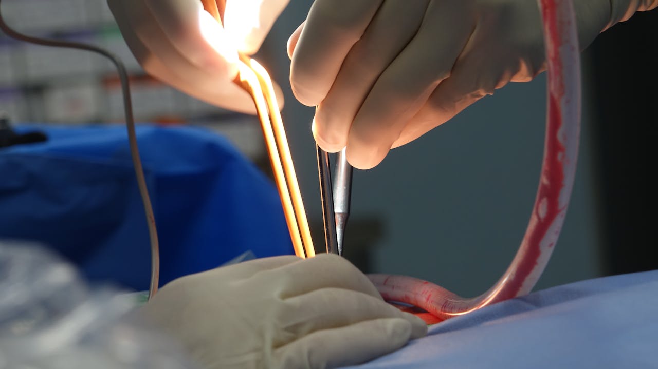 Close-up of a surgeon operating in a sterile environment using surgical instruments.