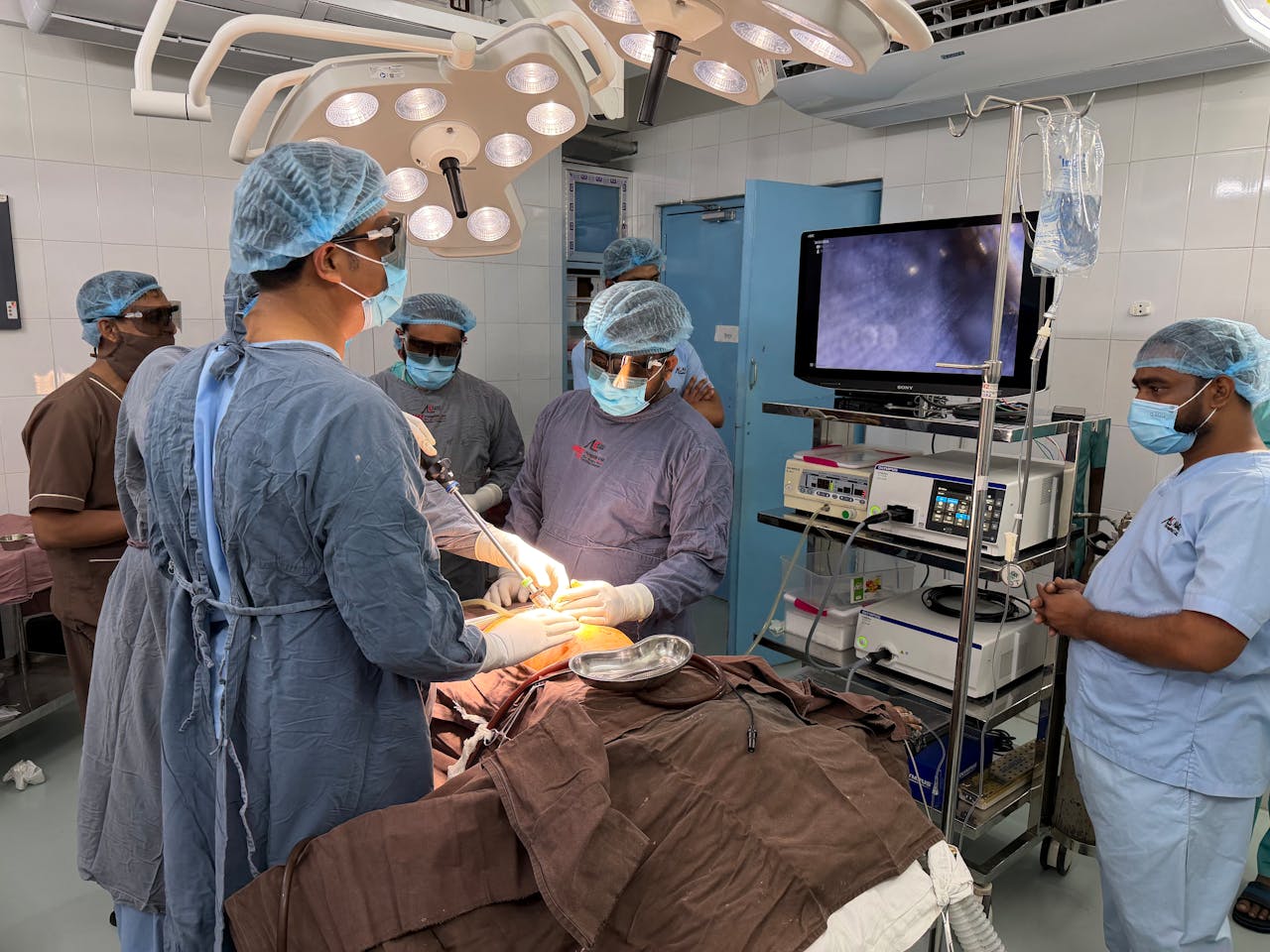 Medical team conducting surgery in Dhaka hospital operating room with advanced equipment.